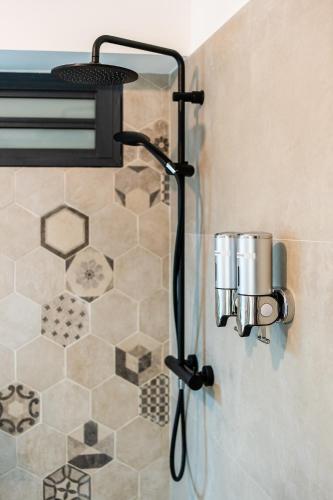 a shower in a bathroom with a shower head at Le Cocon de l'Etang in Bout de lʼÉtang