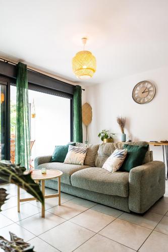a living room with a couch and a large window at Le Cocon de l'Etang in Bout de lʼÉtang