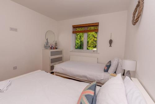 a bedroom with two beds and a window at Seashells in Woolacombe