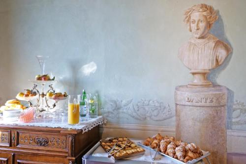 a table with pastries and a statue of a bust at Delcorto Suites in Montepulciano