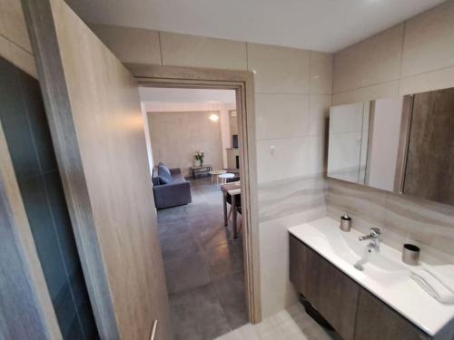 baño con lavabo y espejo y sala de estar. en Andreas' Guest House, en Káto Spílaion