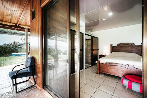 a bedroom with a bed and a sliding glass door at Hotel Little Paradise in Nuevo Arenal