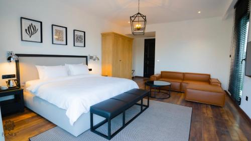 薩姆松的住宿－Be Side Hotel，卧室配有一张白色的大床和一张沙发。