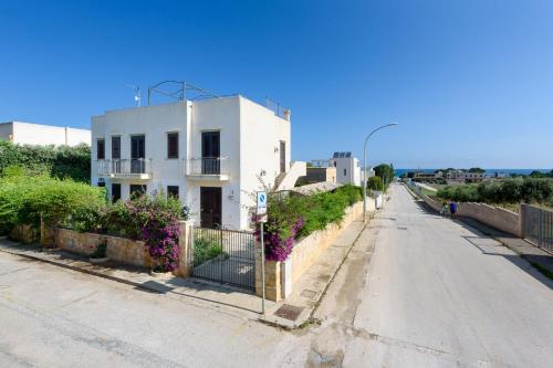 a white house on the side of a road at Casa Vacanza Azzurra in San Vito lo Capo