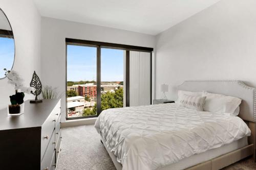 a white bedroom with a large bed and a window at Luxury Apt in West Midtown in Atlanta