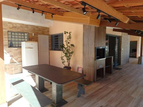 a dining room with a table and a refrigerator at Chácara Rancho Fundo in Águas de Lindóia