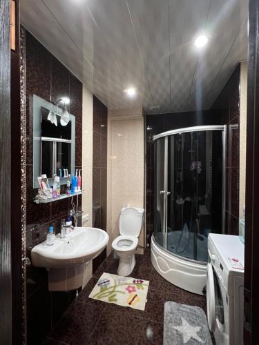 La salle de bains est pourvue de toilettes, d'un lavabo et d'une baignoire. dans l'établissement Old Batumi Apartment, à Batoumi