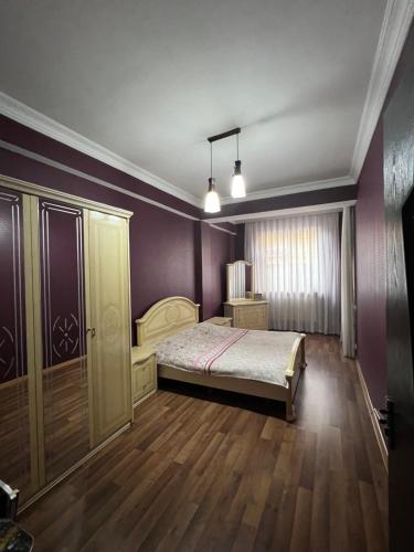 - une chambre avec un lit et des murs violets dans l'établissement Old Batumi Apartment, à Batoumi