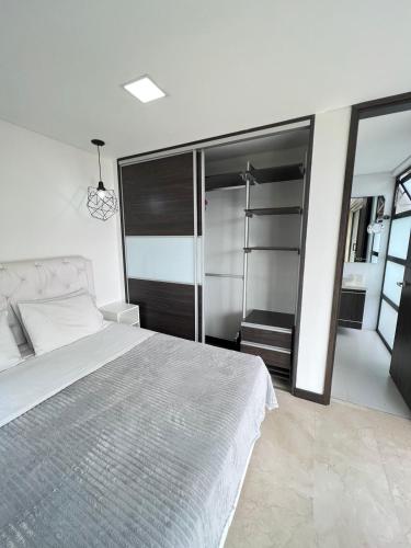 a bedroom with a large bed and a large mirror at Large Apartment High Views and Balcony in Medellín