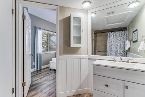 a white bathroom with a sink and a mirror at Leeward 802 in Corpus Christi