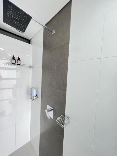 a bathroom with a shower with a laptop on the wall at Large Apartment High Views and Balcony in Medellín