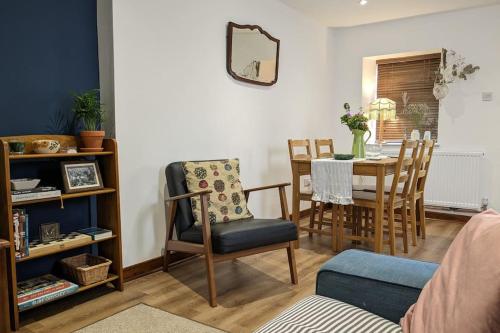 a living room with a dining room table and chairs at Rustic Vintage Cottage: Near Waterfall Country in Pont-Nedd-Fechan