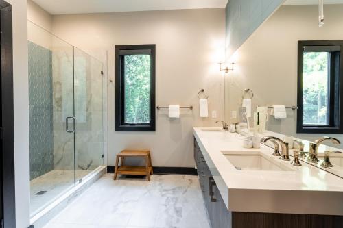 uma casa de banho com 2 lavatórios e um chuveiro em Modern Mountain Creekhouse em Maggie Valley