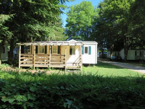 une petite maison dans une cour avec un hangar dans l'établissement Camping Le Ried *** Mobil Home Cosy 3 chambres Proche Europa Park Rulantica, à Boofzheim