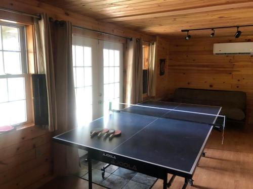 a ping pong table in the corner of a room at Beddington Lake Log Cabin 