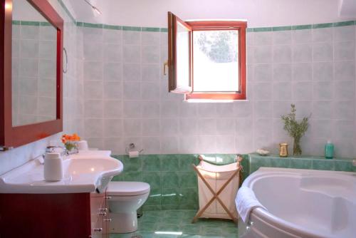 a bathroom with a tub and a toilet and a sink at Round Family Villa near Ancient Olympia & the Sea in Káto Samikón