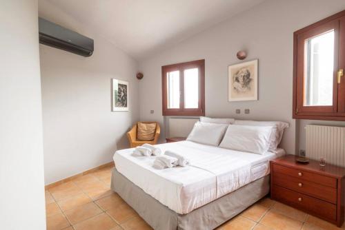 um quarto com uma cama com duas toalhas em Round Family Villa near Ancient Olympia & the Sea em Káto Samikón