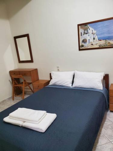 a bedroom with a blue bed with two towels on it at Villa Koutsakis in Kaloi Limenes