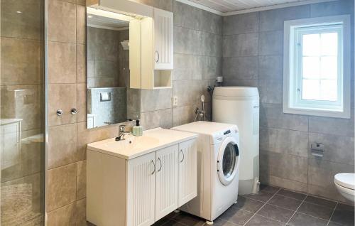 ein Badezimmer mit einer Waschmaschine und einem Waschbecken in der Unterkunft Amazing Home In Osen With House A Panoramic View in Vika