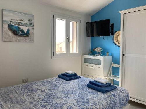 um quarto com uma cama com duas almofadas azuis em Flamingo's House in Sant'Antioco, Sardinia em SantʼAntìoco