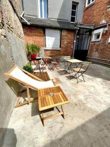 - un groupe de tables et de chaises dans une cour dans l'établissement Studio cosy, calme avec cour extérieure, 1er étage, à Saran