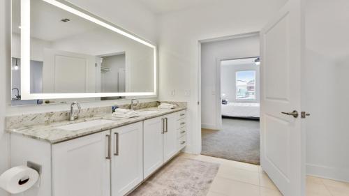 Baño blanco con 2 lavabos y espejo en Beltline 1 bdrm Apt en Atlanta