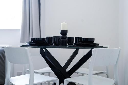 a black table with white chairs in a room at Brighton City Centre Apartment with Two Parking Spaces in Brighton & Hove