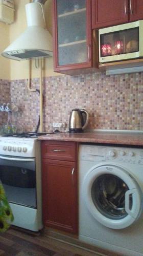 een keuken met een wasmachine en een fornuis bij ДУБОССАРЫ in Corjova