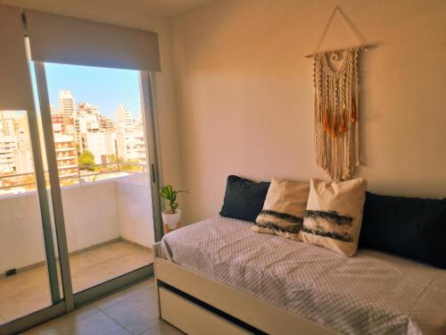 a bedroom with a bed and a large window at Excelente Apartamento Centro Opcional Cochera by Lofter in La Plata