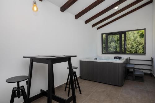 a room with a bath tub and a table and stool at Luxury Apartman Tinel in Mimice