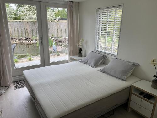 Un dormitorio con una cama grande y una ventana en Villa Lombok, en Eext