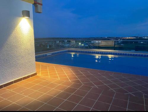 Accra Luxury apartments at Oasis Park Residences في آكرا: مسبح على جانب مبنى في الليل