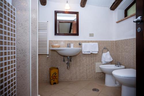 y baño con lavabo, aseo y espejo. en La Locanda del Fiume en Pisciotta