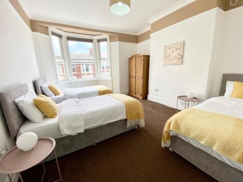 北希爾茲的住宿－3 Queen Alexandra Road，一间卧室设有两张床和窗户。