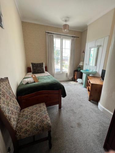 a bedroom with a bed and a chair and a window at Georgian House Hotel in Derby