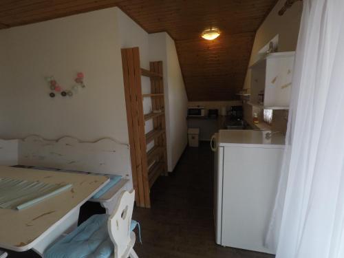 a small room with a table and a kitchen at Napsütötte Kehida in Kehidakustány