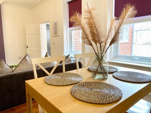 a table with three plates and a vase with feathers at 3 Queen Alexandra Road in North Shields