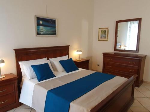 a bedroom with a large bed with blue and white pillows at Unico Gravina in Gravina di Catania