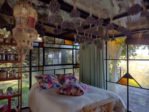 a bedroom with a bed and a bunch of windows at LOFT DE MONTAÑA -LaS RABONAS - PISCINA EXCLUSIVA in Las Rabonas