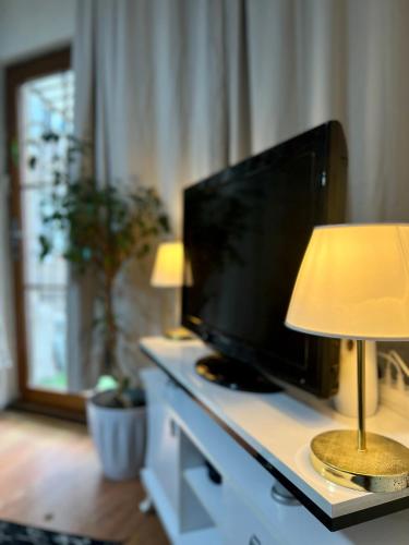 een woonkamer met een televisie en een tafel met een lamp bij 1+1 İstiklal caddesine 100 metre in Istanbul