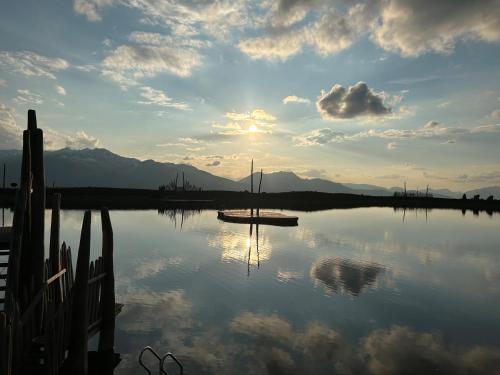a boat is sitting on a lake with the sunset at Appartement Ginzling Haus Eder in Ginzling