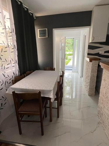 a dining room with a white table and chairs at Apartman Glorija in Kotor