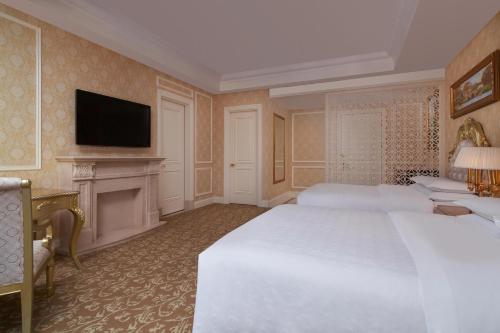 a bedroom with a large white bed and a fireplace at Sheraton Chongqing Hotel in Chongqing