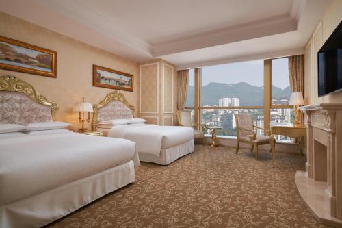 a hotel room with two beds and a large window at Sheraton Chongqing Hotel in Chongqing