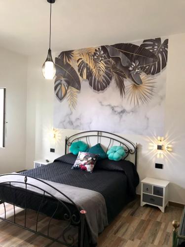 a bedroom with a black bed with a wall mural at Il melograno in Usini