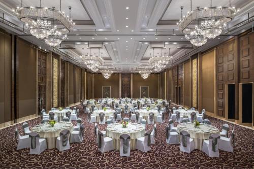 a large banquet hall with white tables and chandeliers at The St. Regis Mumbai in Mumbai