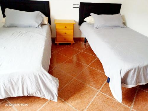 two beds sitting next to each other in a room at PISO HARLEY in Camariñas