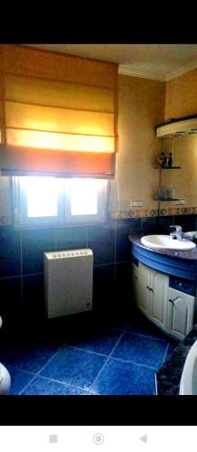 a small bathroom with a sink and a window at PISO HARLEY in Camariñas