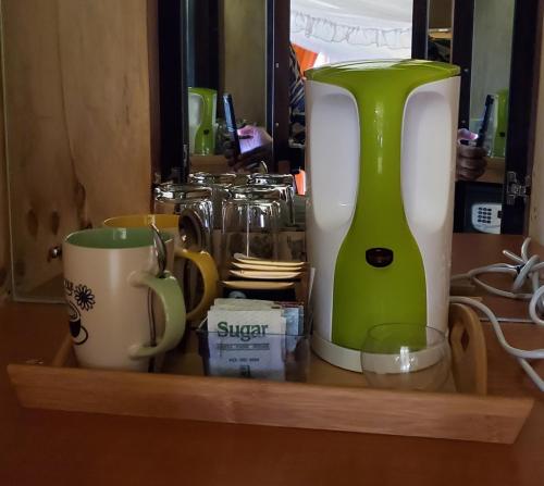 un estante con una cafetera y tazas. en Edaala Comfort - B&B, en Nairobi