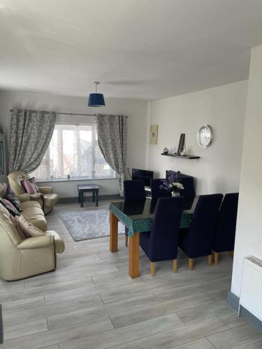 uma sala de estar com uma mesa de jantar e cadeiras em The Bungalow Castlepollard em Westmeath
